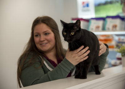 Woman smiling and holding a black cat
